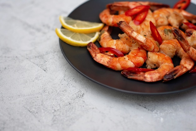 Tasty cooked fried shrimp with chilli and lemon. Healthy seafood. Copy space. Flat lay.