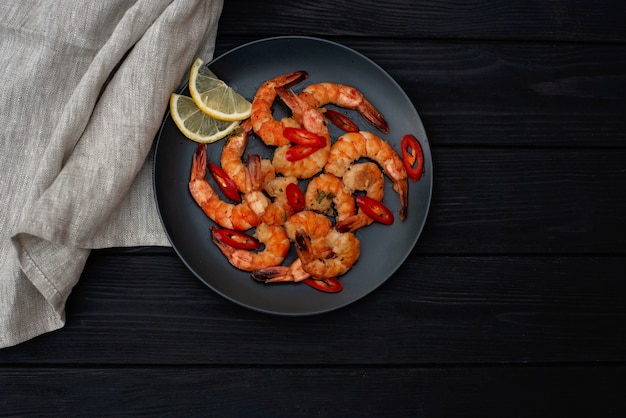 Tasty cooked fried shrimp with chilli and lemon. Healthy seafood. Copy space. Flat lay.