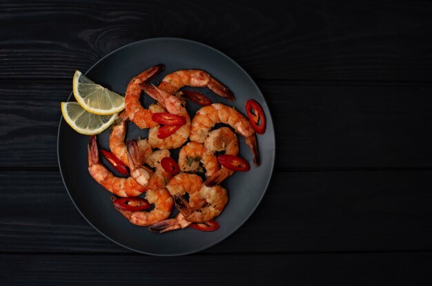 Tasty cooked fried shrimp with chilli and lemon. Healthy seafood. Copy space. Flat lay.