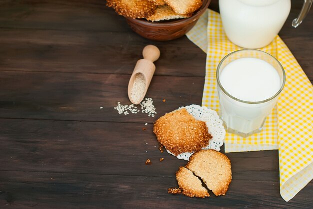 Tasty cookies and glass of milk on rustic wooden background