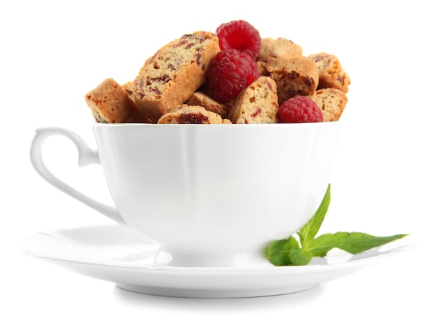 Tasty cookies with raspberries in cup isolated on white