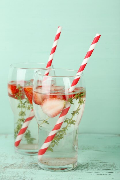 Photo tasty cool beverage with strawberries and thyme on wooden background