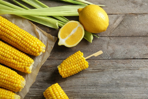 Tasty corn cobs on wooden table