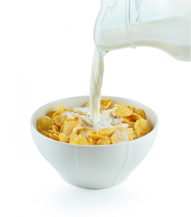 Photo tasty cornflakes in white bowl and glass of milk on white background