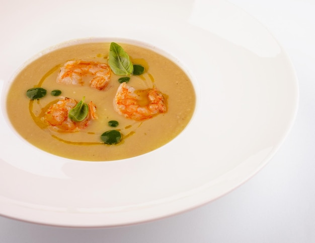 Tasty cream soup with fresh shrimps on table