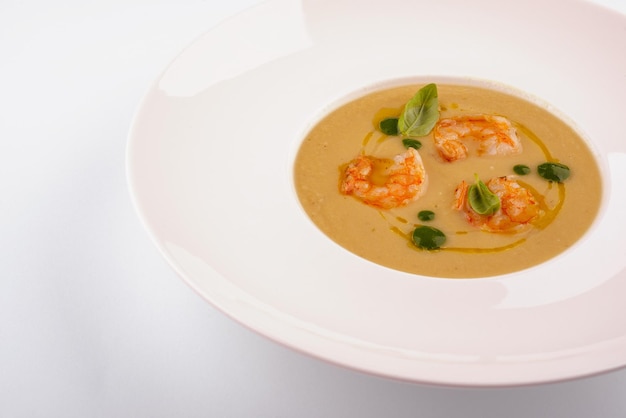 Tasty cream soup with fresh shrimps on table