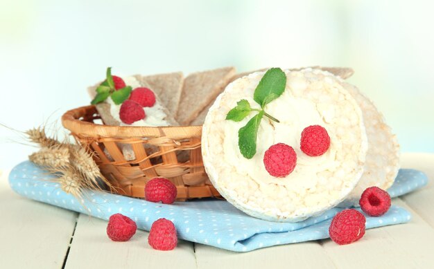 Tasty crispbread with berries in wicker basket on white table
