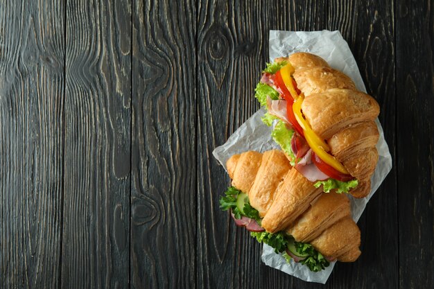 Tasty croissant sandwiches on wooden