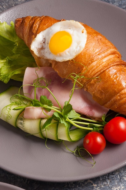 Tasty croissant with ham cucumber and egg Concept Breakfast