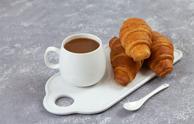 Gustosi croissant e tazza di caffè sul vassoio in ceramica