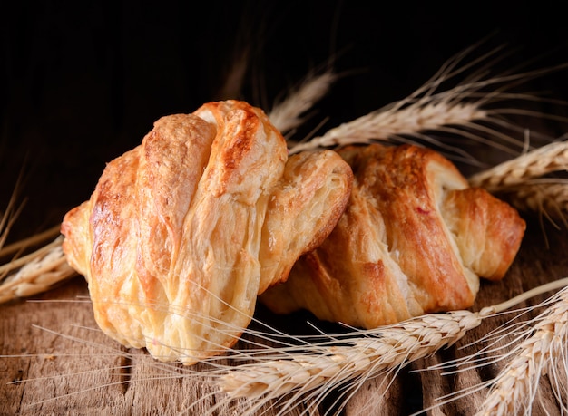 Tasty croissants on wooden background.