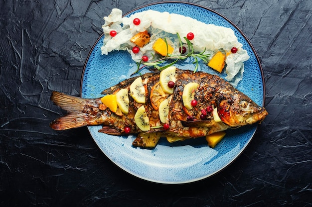 Tasty crucian fried with kiwi and mango