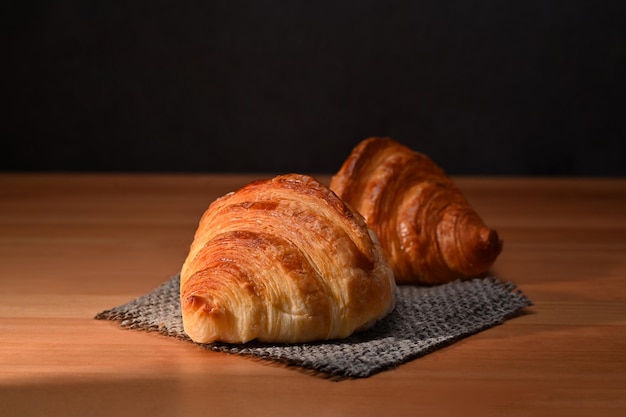 Gustosi croissant al burro croccanti su tavola di legno pane per la colazione prodotti da forno concetto di caffetteria