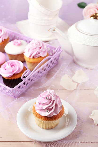 Tasty cupcake on saucer on white tablecloth