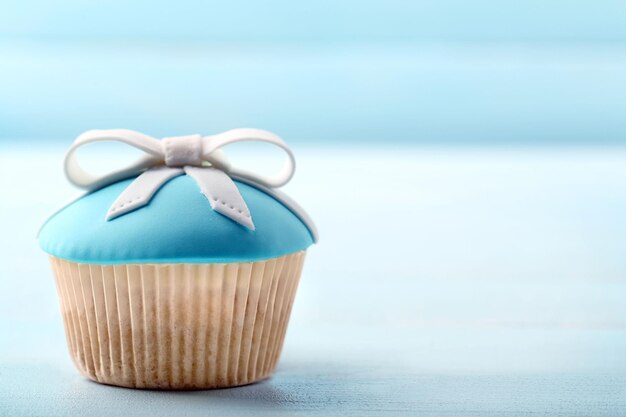 Tasty cupcake with bow on color wooden background