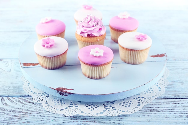 Tasty cupcakes on color wooden background