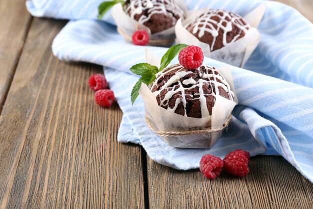 Tasty cupcakes with raspberries on table closeup