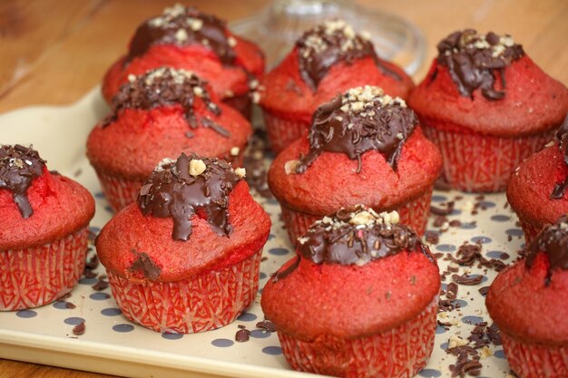 Tasty cupcakes with red cream and chocolate