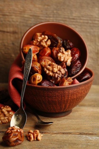 Tasty dates fruits in bowls on wooden background