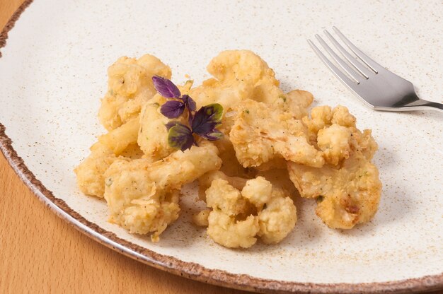 Tasty deep-fried cauliflower on a plate close up