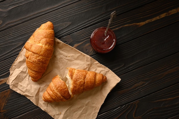 Tasty and delicious croissants with jam on a wooden table