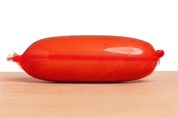 Tasty delicious sausage on wooden table on white background