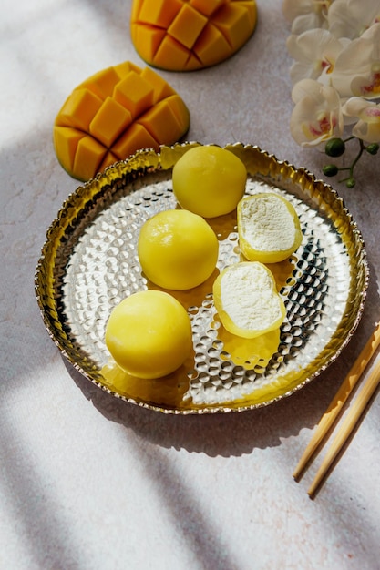 Dessert gustoso mochi con frutta mango su sfondo grigio primo piano