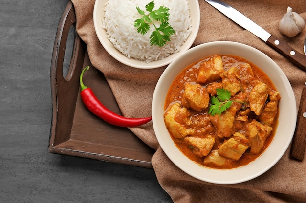 Tasty dinner with chicken curry in plate on tray