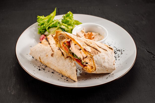 Tasty dish of pita with meat and vegetables on wooden background