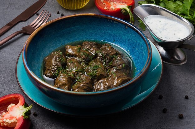 Tasty dolma with meat in grape leaf and kefirbased sauce