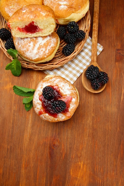 Tasty donuts with berries on wooden table