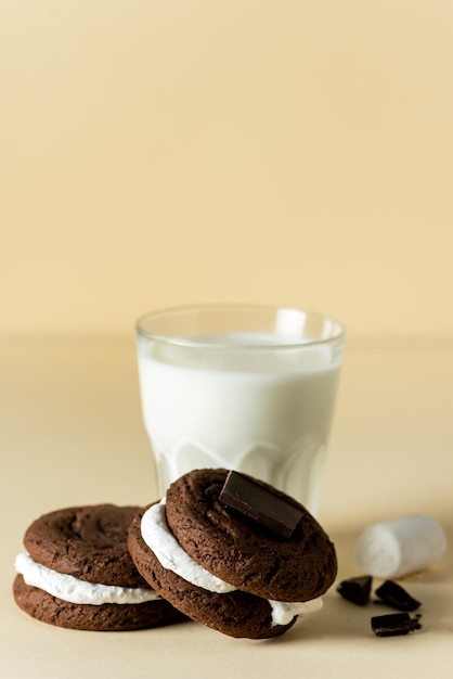 Tasty Double Chocolate Chip Cookies and Glass of Milk Yellow Background Vertical