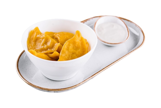 Tasty dumplings in bowl with sour cream