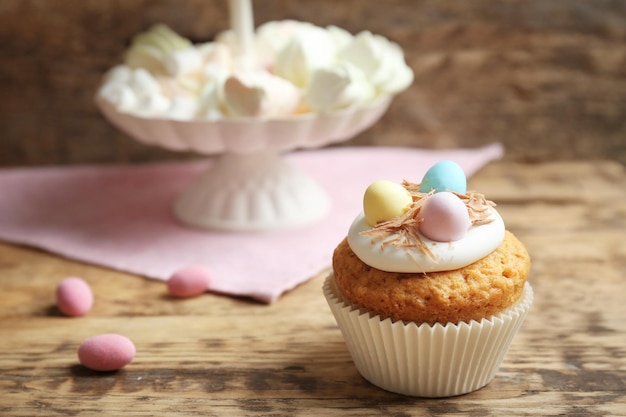 Tasty Easter cupcake on wooden table