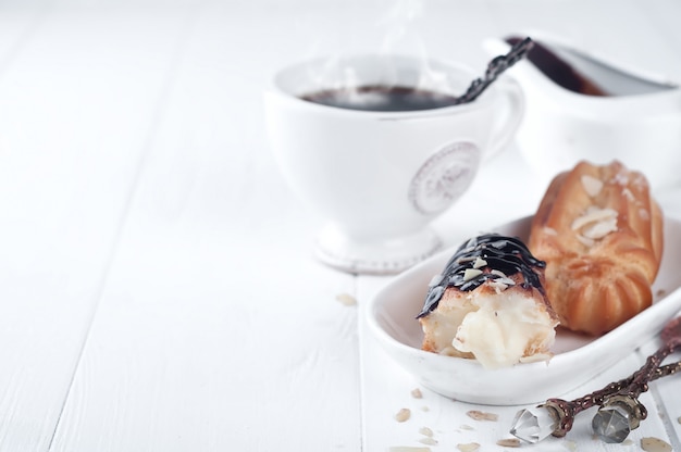 Tasty eclairs on table