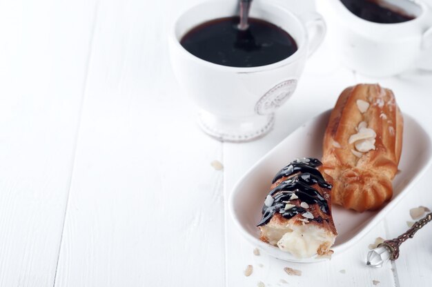 Tasty eclairs on table