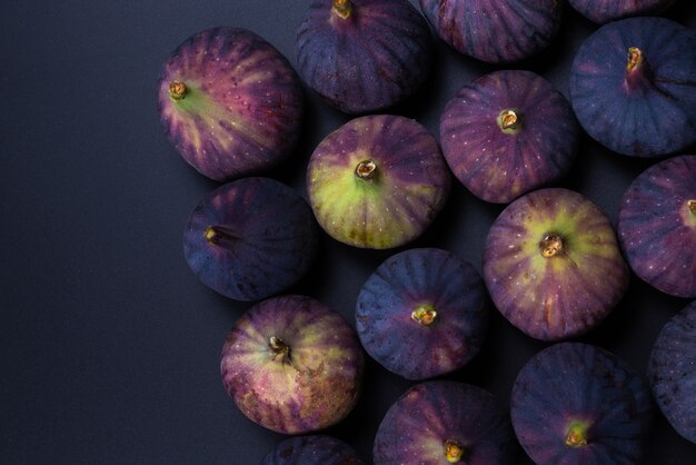 Photo tasty figs on a black wall. top view. slices.