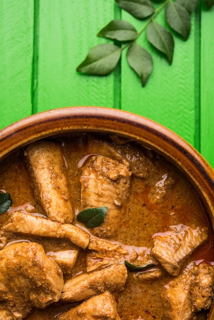 Photo tasty fish curry served with white cooked basmati rice with curry leaves in the background, favourite coastal indian food