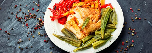 Tasty fish grenadier baked with vegetables.Seafood on slate background