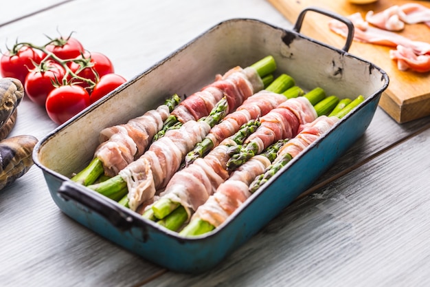 Tasty food bacon wrapped asparagus in frying pan.