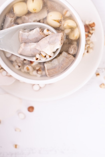 Tasty Four Tonics Herb Flavor Soup, Taiwanese traditional food with herbs, pork intestines on white wooden table, close up, flat lay, top view.