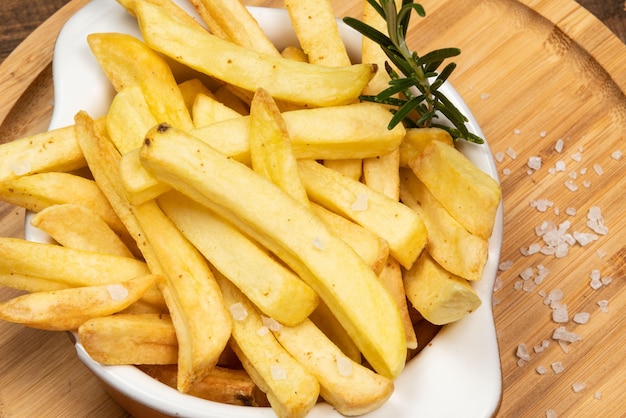 Tasty french fries on plate on bowl