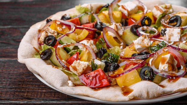 Tasty fresh Greek salad on a pita cooked for a festive table