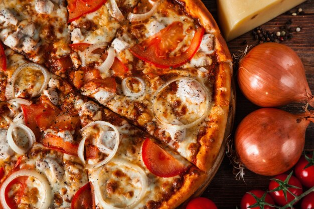 Tasty fresh italian pizza with cheese, onion and tomatoes closeup. Italian food.