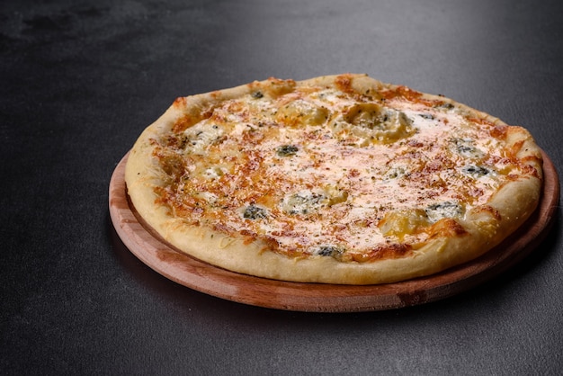 Tasty fresh oven pizza with tomatoes, cheese and mushrooms on a dark concrete background. Italian cuisine