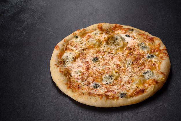 Tasty fresh oven pizza with tomatoes, cheese and mushrooms on a dark concrete background. Italian cuisine