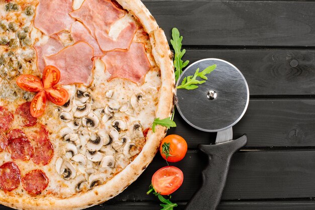木製の背景に1つに4つの異なる部分を持つおいしい新鮮なピザ