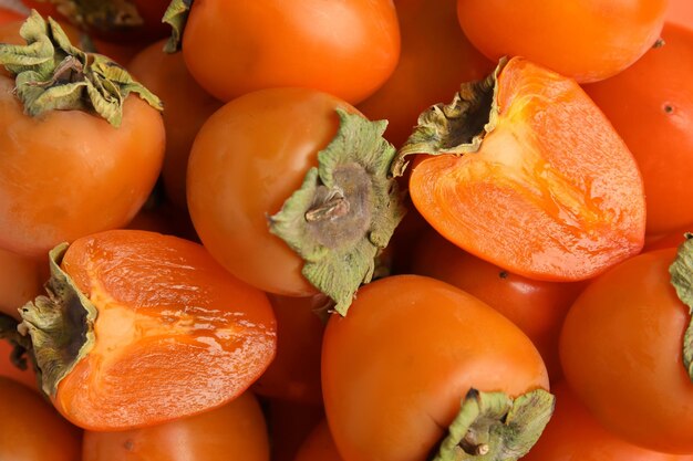 Tasty fresh ripe persimmons as background closeup