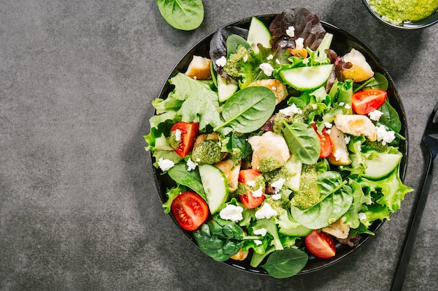 Photo tasty fresh salad with chicken, pesto and vegetables