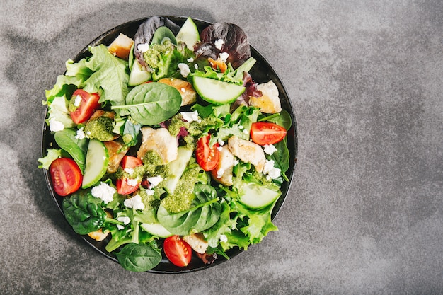 Tasty fresh salad with chicken, pesto and vegetables